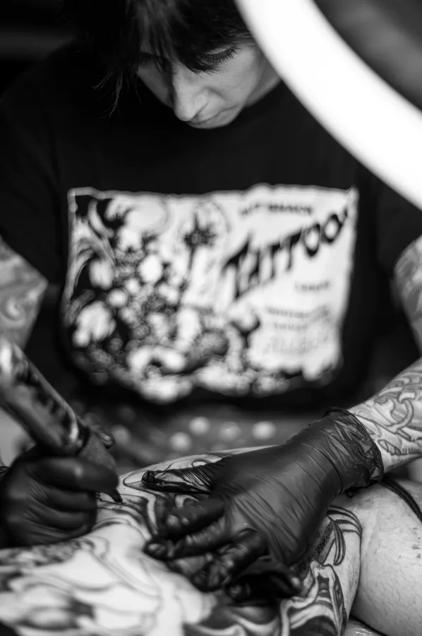 Detalle de las manos de María tatuando, en blanco y negro.