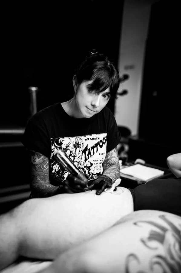 María mirando a cámara mientras sujeta la máquina, en blanco y negro.