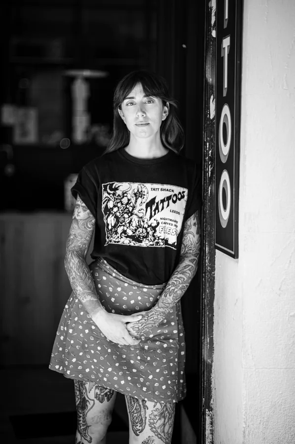 Retrato de María de cuerpo entero en la puerta del estudio, en blanco y negro.
