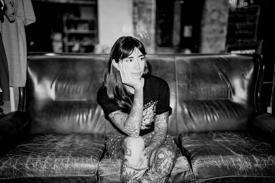 María sentada en el sofá del estudio, otra toma en blanco y negro.