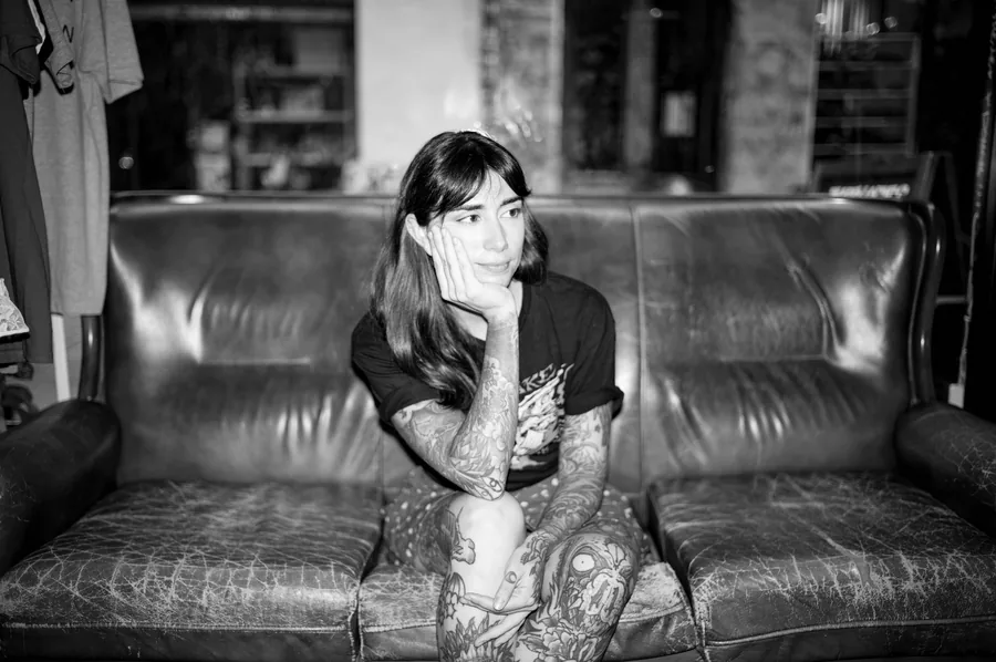 María sentada en el sofá del estudio, en blanco y negro.