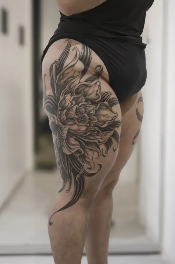 Muslo de perfil con la gran flor de pétalos abiertos y hojas en movimiento, black & grey de sombreado suave.