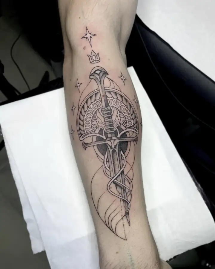 Sobre el antebrazo, una espada cruza un arco de filigrana entre estrellas; ornamental, de línea fina y dotwork.