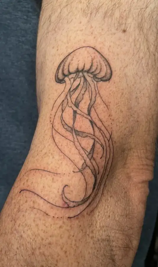 Brazo con una medusa de tentáculos largos y ondulantes, trazada solo con línea fina.