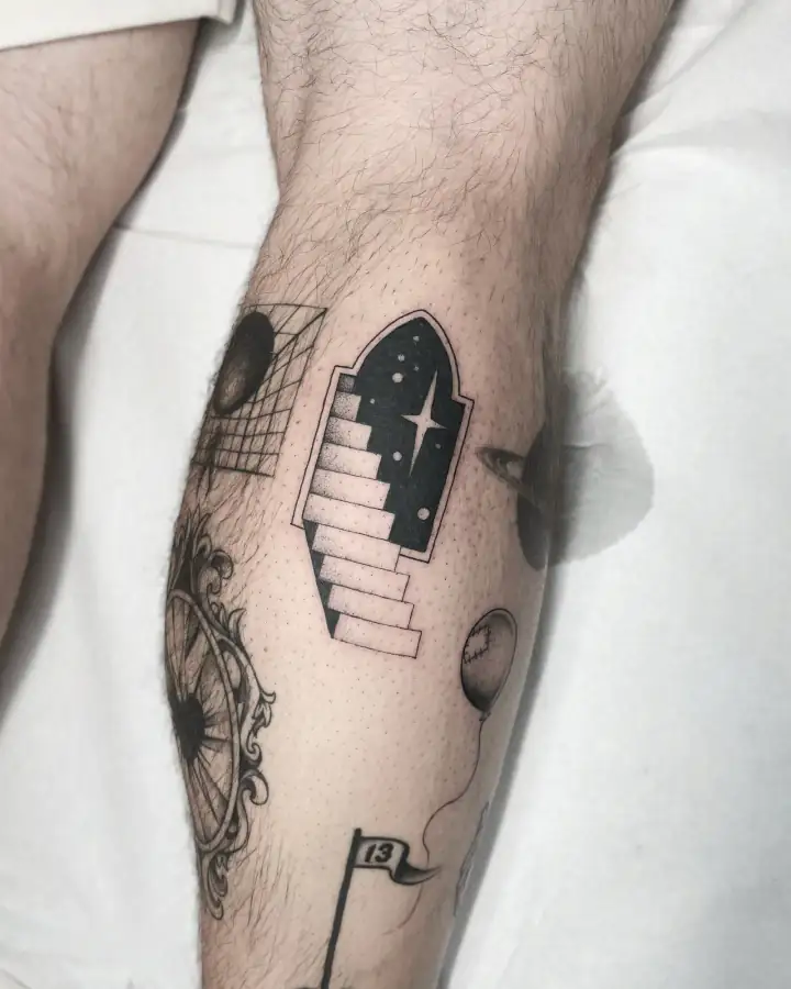 Rodilla y pantorrilla con una escalera que sube hacia un portal lleno de estrellas, en blackwork de degradado punteado.