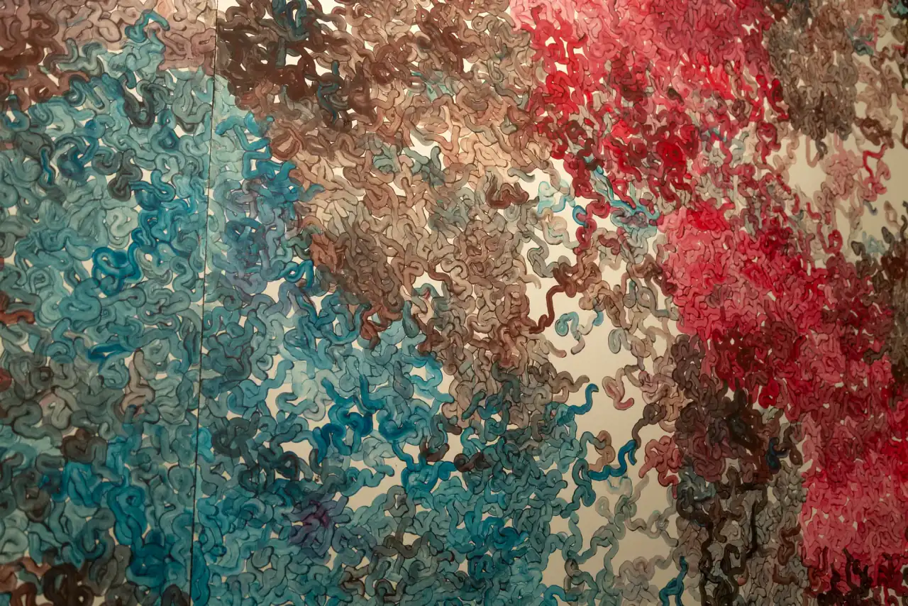 MUR MUR (detalle), pintura sobre papel (2018). Detalle de mural en esquina: masa de bucles turquesa a la izquierda y pardos y rojos a la derecha.