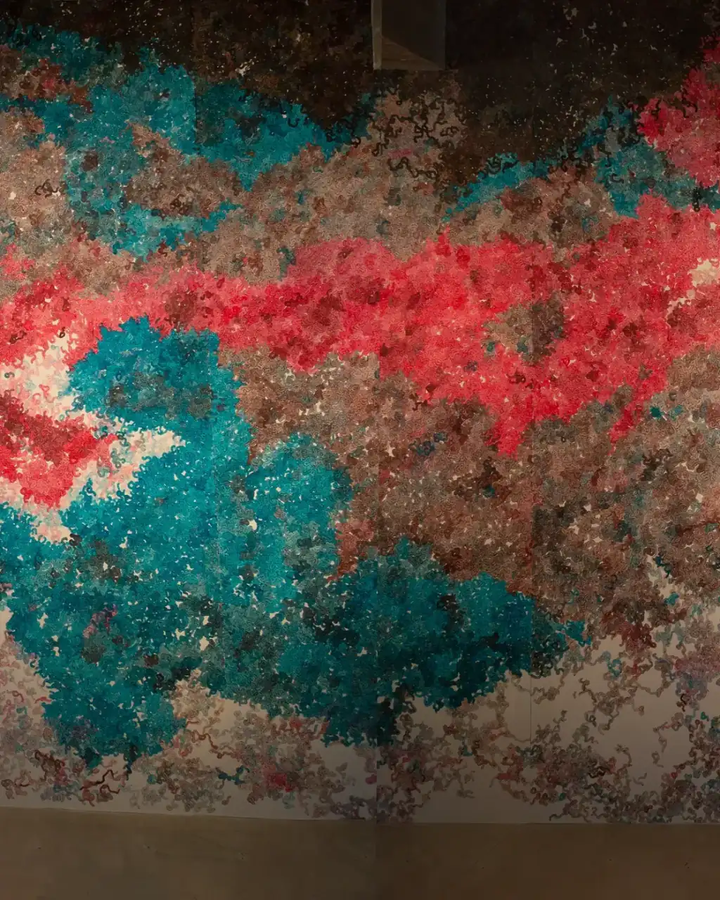 MUR MUR, pintura sobre papel (2018). Fragmento 4 de 6 de la panorámica del mural de pintura sobre papel: una franja roja horizontal atraviesa la mitad superior sobre una masa turquesa, con zonas pardas y rosadas alrededor y el suelo abajo.