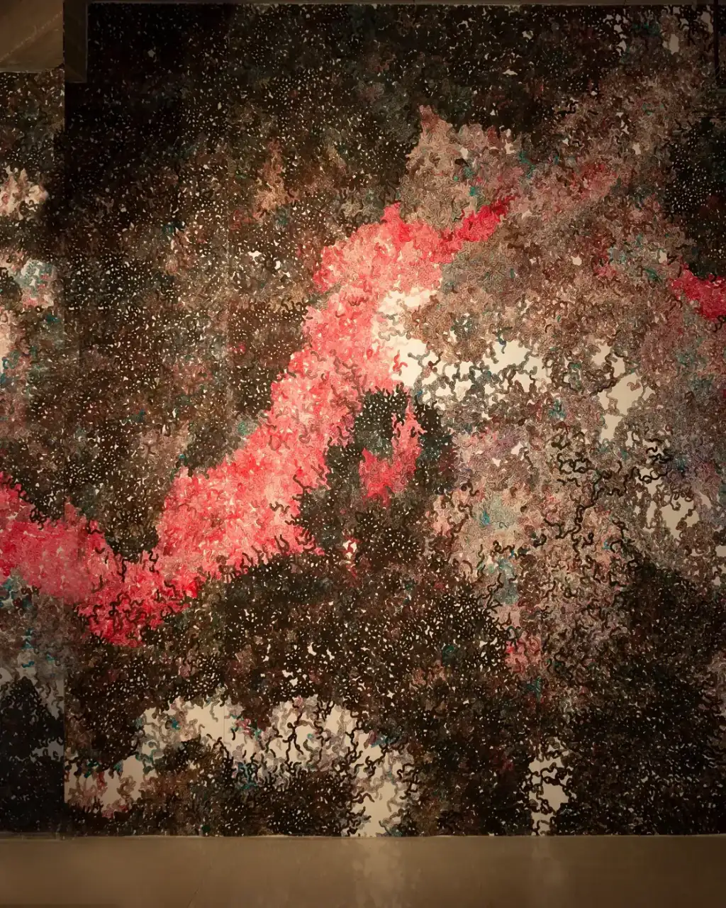 MUR MUR, pintura sobre papel (2018). Fragmento 6 de 6 de la panorámica del mural de pintura sobre papel: un trazo rojo sube en diagonal sobre un fondo pardo oscuro, con formas blancas en la parte inferior.