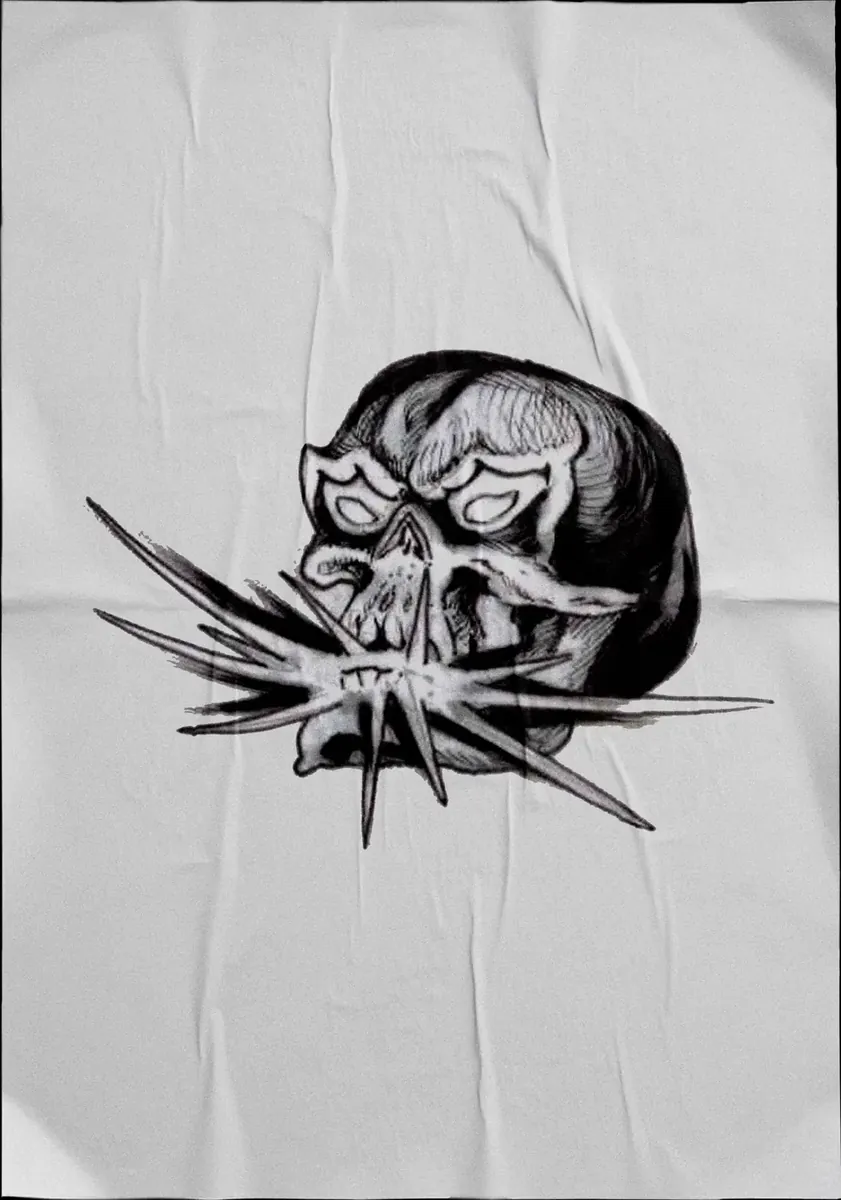 Diseño de tatuaje en negro sobre tela: calavera con espinas atravesadas.