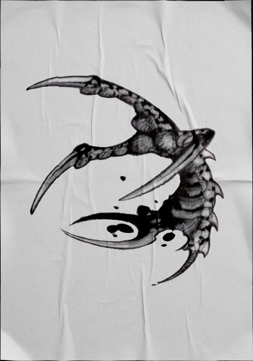 Diseño de tatuaje en negro sobre tela: garra con yin-yang entre las uñas.