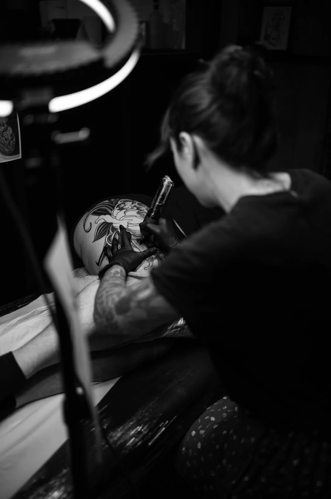 María tatuando bajo el aro de luz, vista desde arriba.