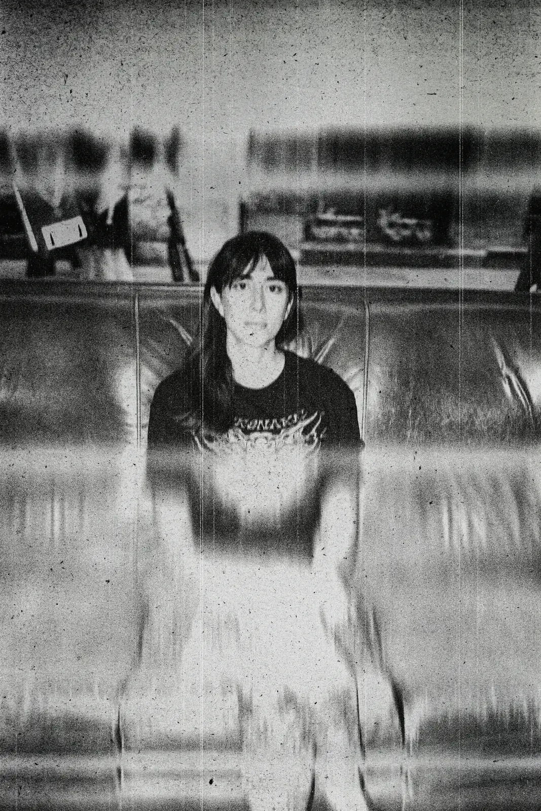 Retrato frontal granulado de María con camiseta negra, de pie, con efecto de barrido vertical.
