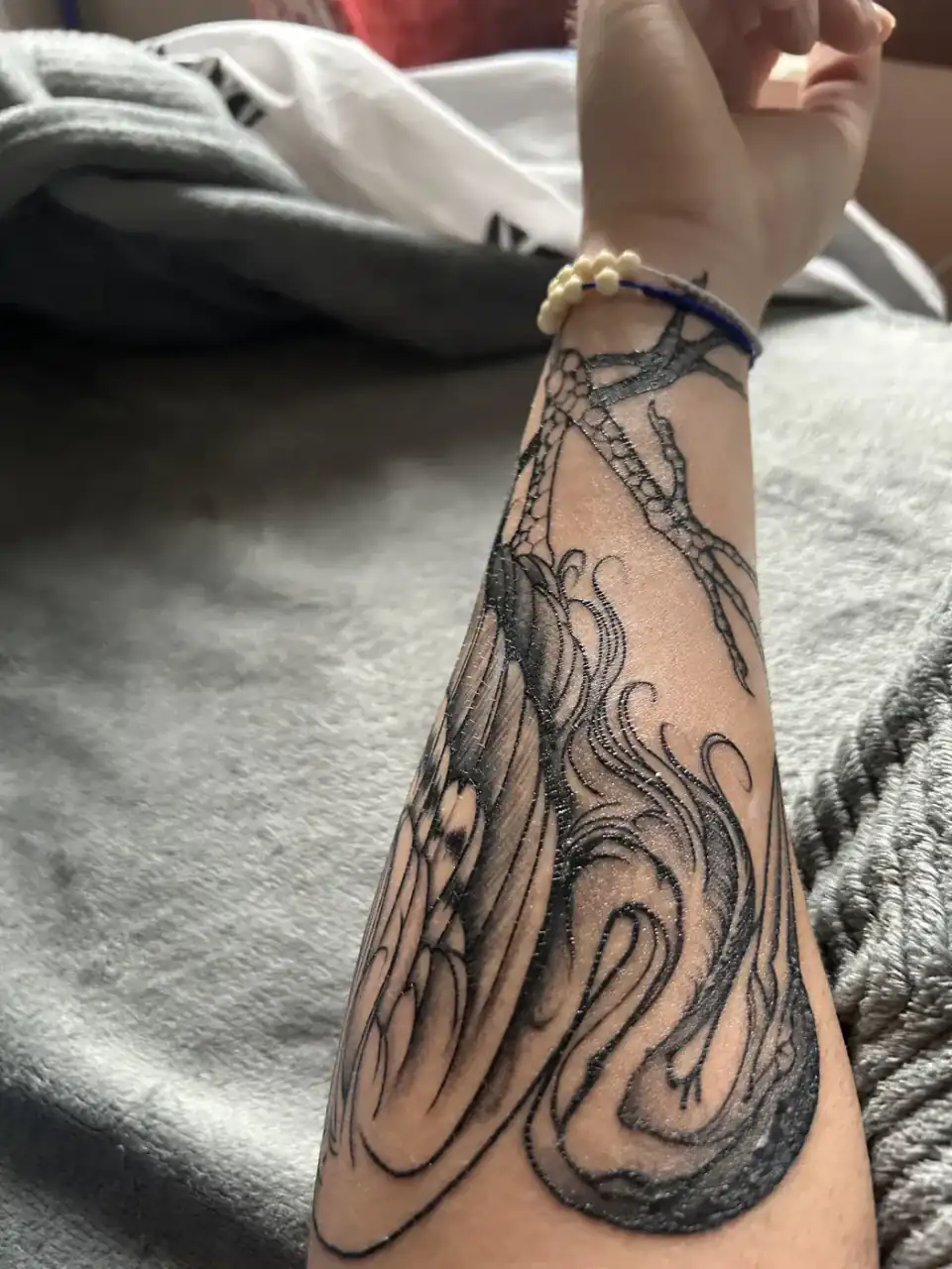En el antebrazo, un pulpo enrosca sus tentáculos hasta la muñeca, en blackwork con sombreado suave.