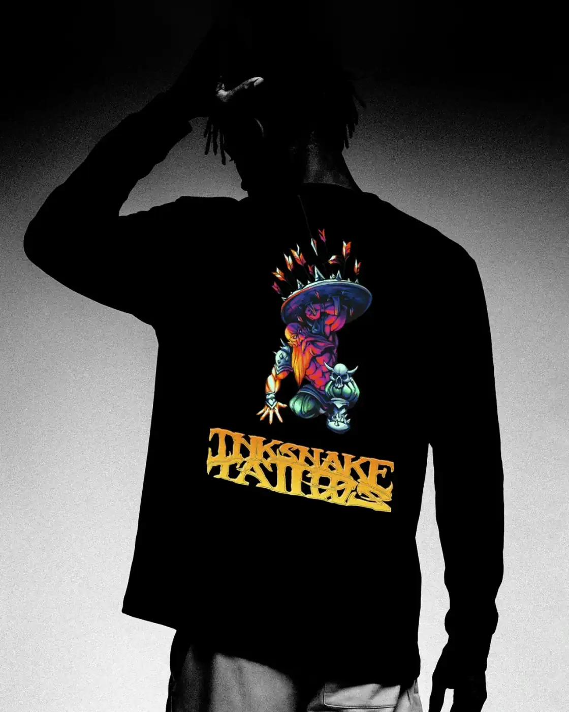 Maqueta de camiseta negra de manga larga con una criatura a color y el logotipo dorado de InkSnake Tattoo.